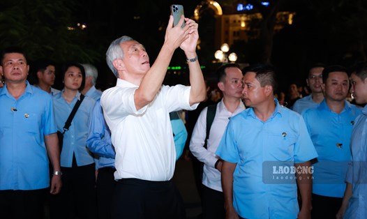 Thủ tướng Singapore Lý Hiển Long dùng điện thoại ghi lại nhiều bức hình khi dạo phố đi bộ Hồ Gươm. Ảnh: Hải Nguyễn
