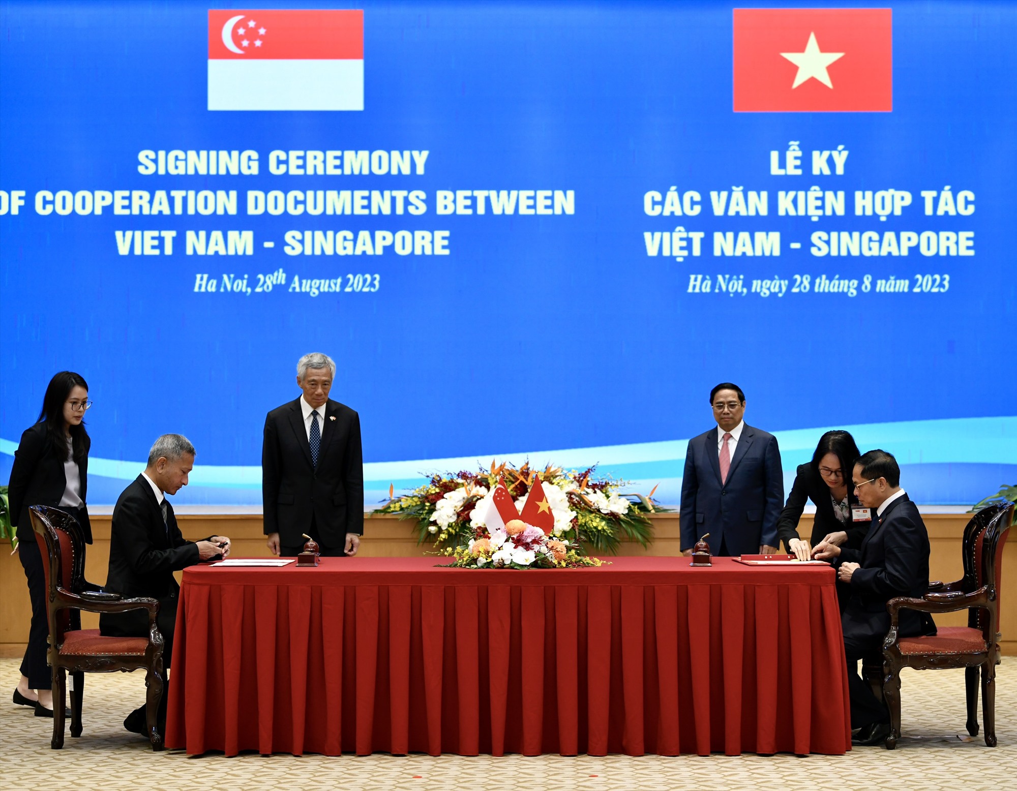 Bộ trưởng Bộ Ngoại giao Bùi Thanh Sơn (ngồi, phải) và Bộ trưởng Bộ Ngoại giao Singapore Vivian Balakrishnan (ngồi, trái) ký thỏa thuận hợp tác. Ảnh: Hải Nguyễn