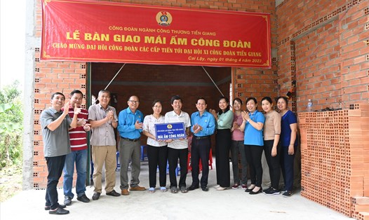 Chủ tịch LĐLĐ tỉnh Tiền Giang Lê Minh Hùng (thứ 6 từ phải sang) trao tặng “Mái ấm Công đoàn” cho một gia đình công nhân lao động trên địa bàn tỉnh. 
Ảnh: Thành Nhân