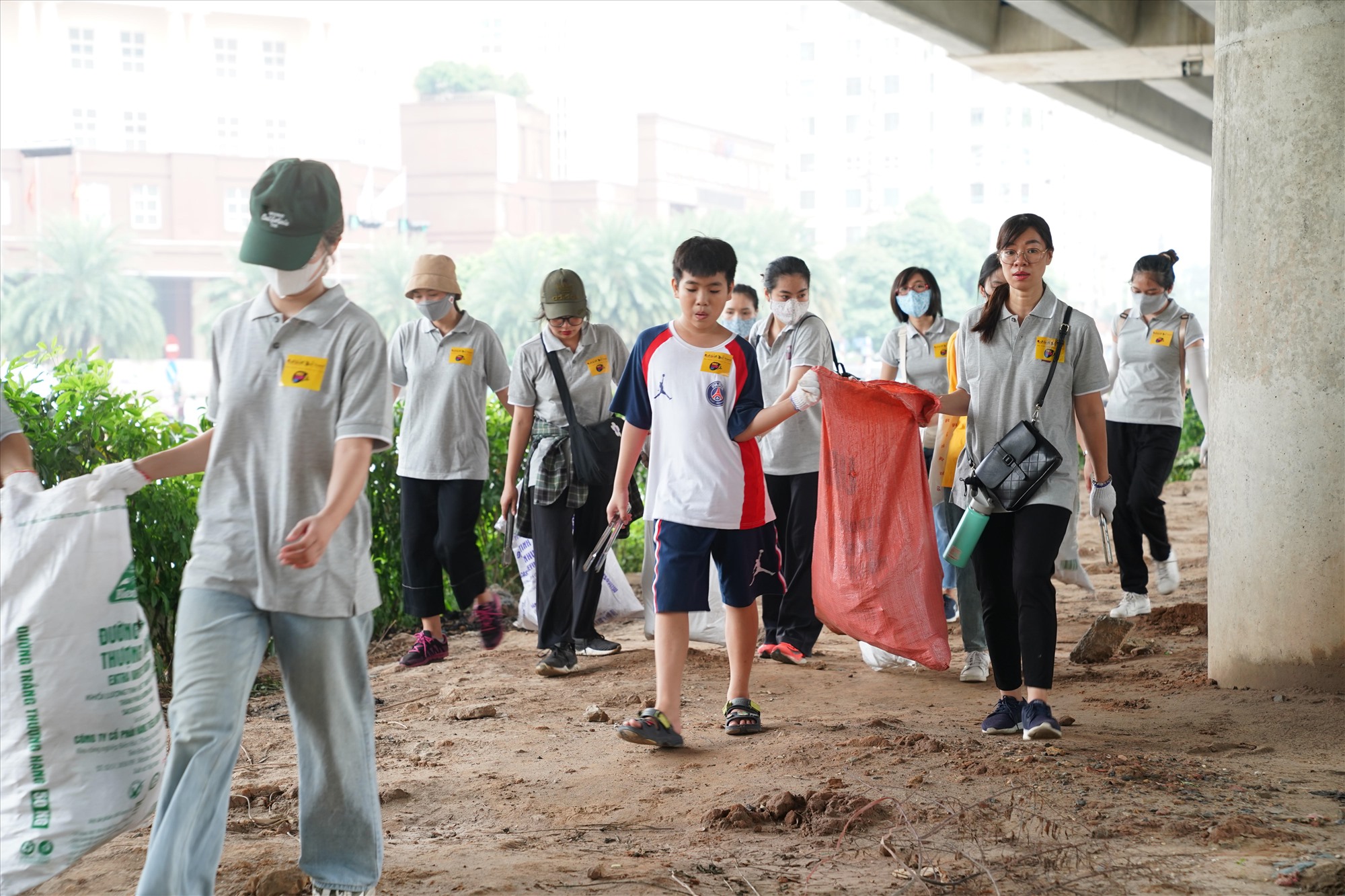Nhiều em nhỏ và phụ huynh trở thành tình nguyện viên trong chương trình dọn rác ở Hà Nội. Ảnh: Hương Giang