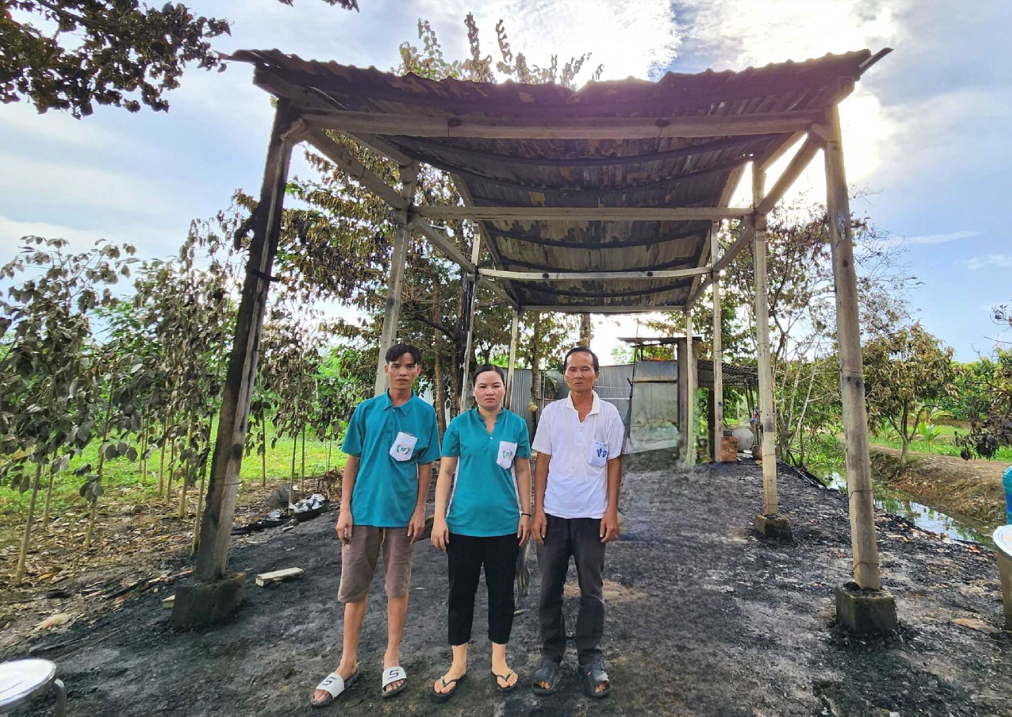 Đoàn viên Nguyễn Thị Kim Anh (giữa) cùng chồng và cha trước hiện trường  cháy nhà.  Ảnh: CĐCS Công ty TNHH Liên doanh Nghị Phong cung cấp