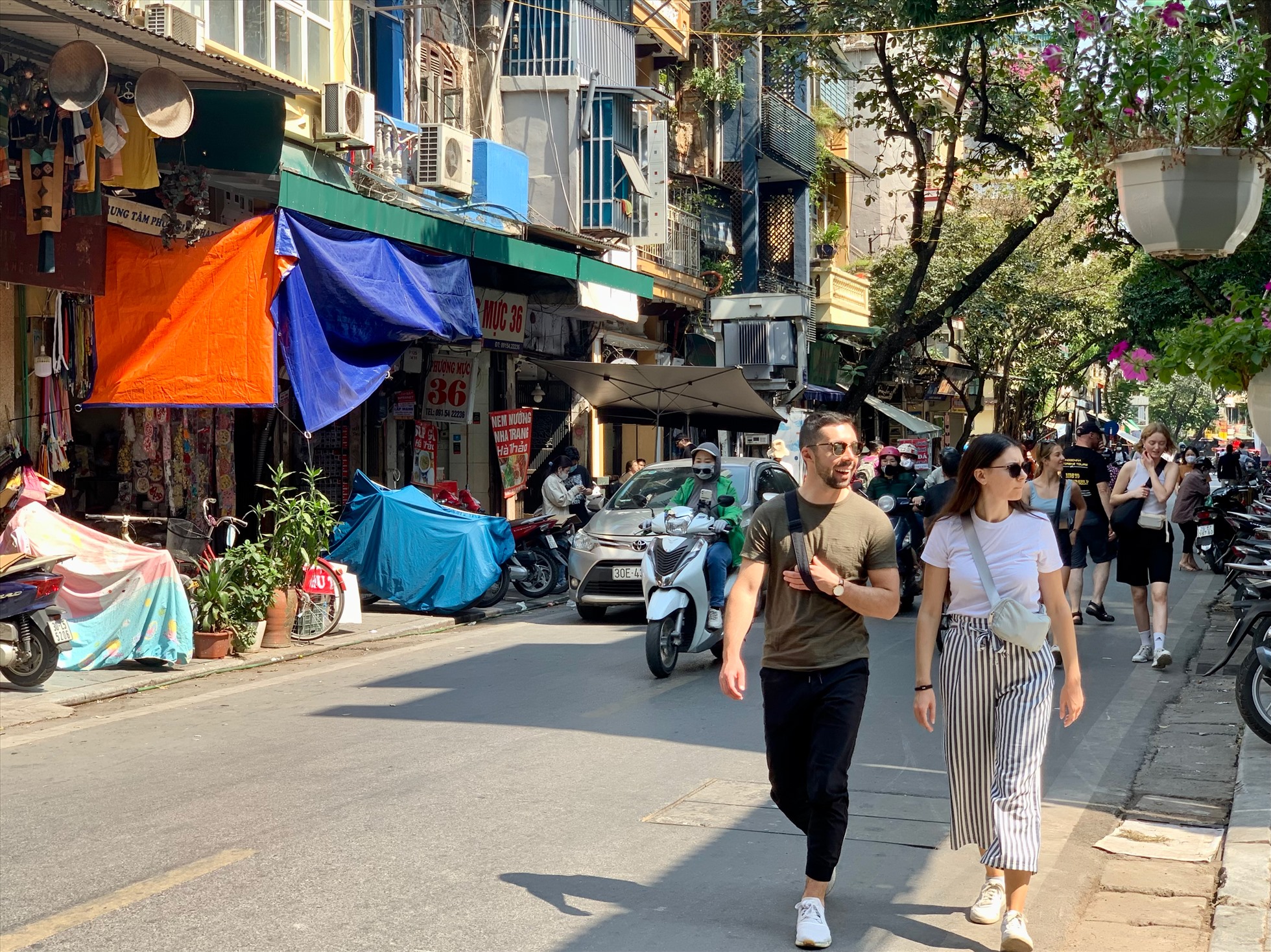 Khách du lịch dạo chơi trên phố Hàng Bồ, Hà Nội. Ảnh: Ý Yên