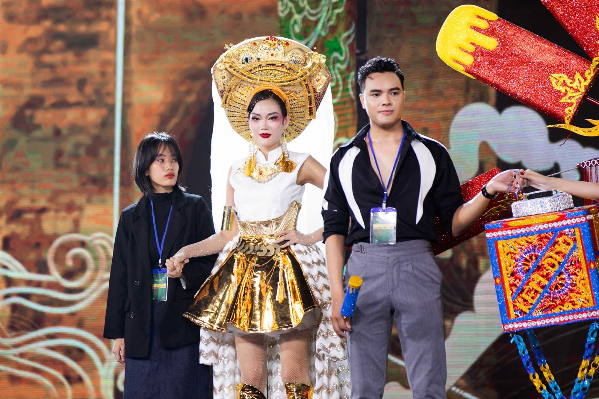 Nhà thiết kế trẻ Trần Thị A Khìn (ngoài cùng bên trái) và trang phục “Vũ rối“. Ảnh: Sen Vàng. 