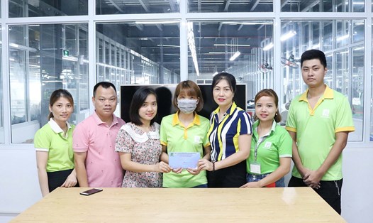 Ban chấp hành Công đoàn Nhà máy Pro Sports Hồng Thuận trao số tiền ủng hộ cho chị Trang. 
Ảnh: Công đoàn Pro Sports Hồng Thuận