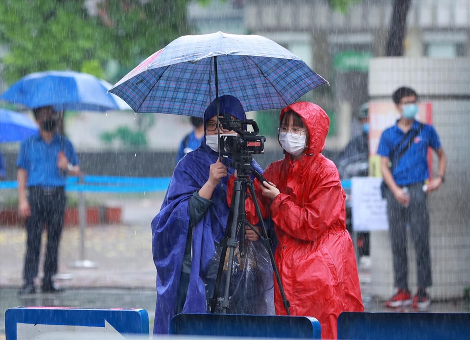 Phóng viên tác nghiệp dưới thời tiết mưa bão. Ảnh: Hải Nguyễn