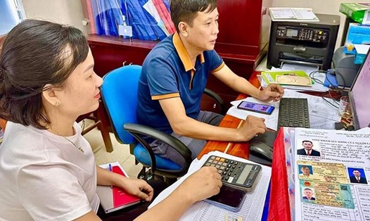 Nhân viên Trung tâm Y tế thị xã Hồng Lĩnh giúp người dân khi đến khám sức khỏe tại đây làm thủ tục đổi giấy phép lái xe. Ảnh: Thu Hằng.