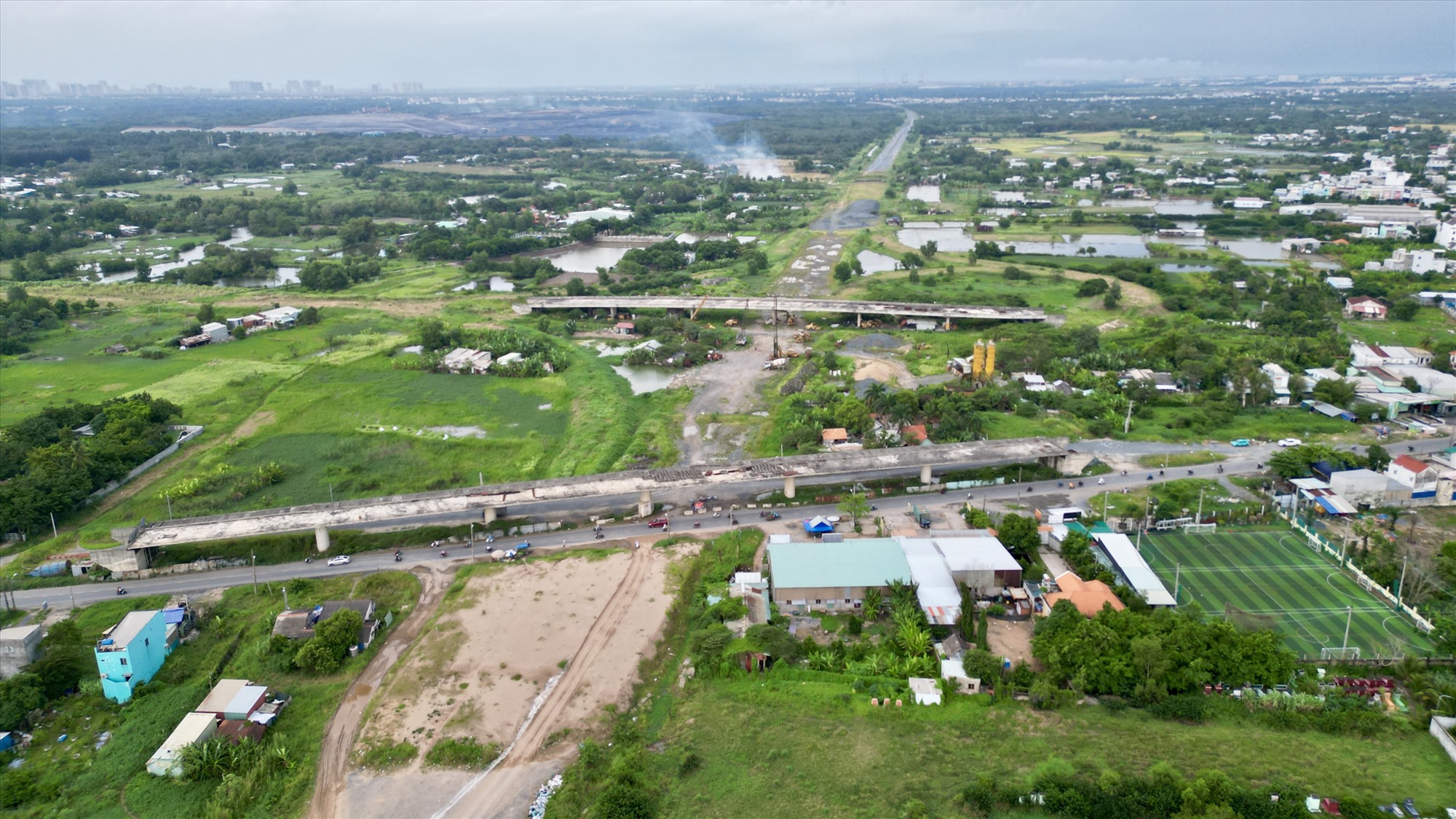 Công trường cao tốc đoạn giao nhau với quốc lộ 50, huyện Bình Chánh vẫn dang dở. Hai cầu dẫn từ tuyến quốc lộ lên cao tốc nằm trơ trọi, nhiều đoạn bêtông xám xịt vì phơi nắng mưa lâu ngày.