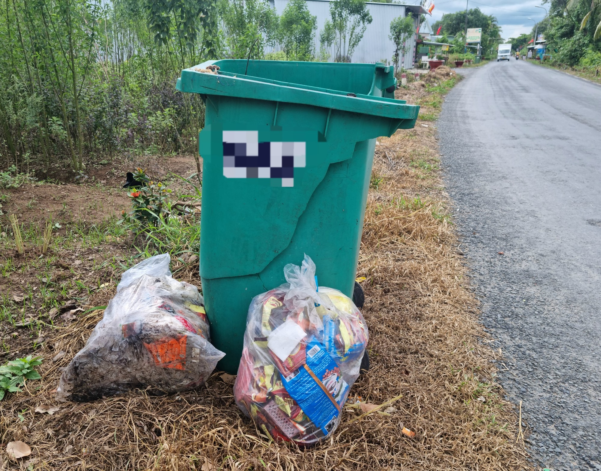 Trên địa bàn huyện có nhiều thùng chứa rác bị hư hỏng, không có nắp đậy nên để xảy ra tình trạng rác vương vải ngoài đường và nước chứa trong thùng rác. Ảnh: Hoàng Lộc