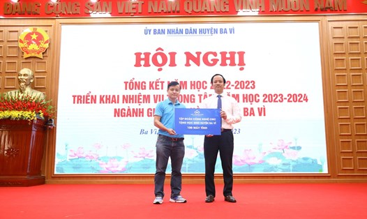 Ông Nguyễn Thành Lưu (áo xanh), đại diện Tập đoàn Công nghệ CMC trao tặng 100 bộ máy tính cho huyện Ba Vì, Hà Nội. Ảnh: CMC 