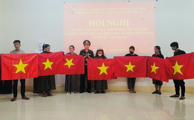 Lực lượng BĐBP Quảng Bình trao tặng cờ Tổ quốc cho người dân vùng biên giới. Ảnh: Đức Trí