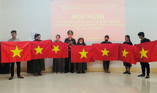 Lực lượng BĐBP Quảng Bình trao tặng cờ Tổ quốc cho người dân vùng biên giới. Ảnh: Đức Trí