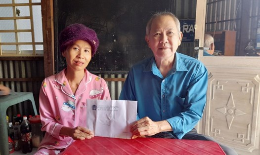 Phó Chủ tịch LĐLĐ huyện Thoại Sơn Nguyễn Thành Trước thăm hỏi và trao tiền hỗ trợ cô Nhung. Ảnh: Kim Anh