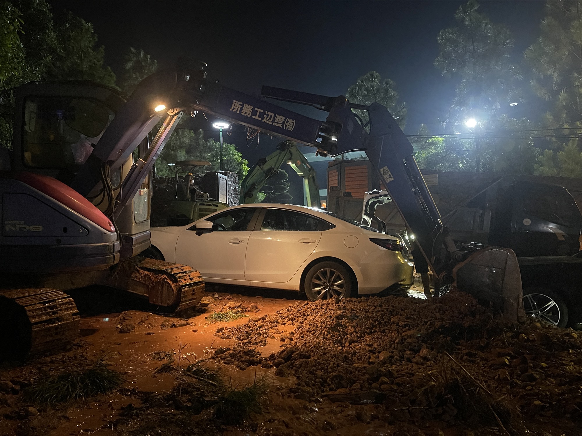 Lực lượng chức năng dùng máy xúc để giải phóng bùn đất, cứu hộ các ô tô, ảnh chụp tối 4.8. Ảnh: Khánh An