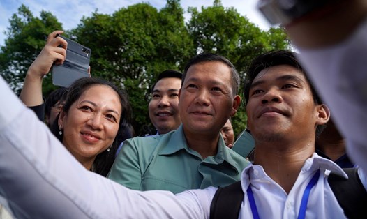 Ông Hun Manet (giữa) và vợ, bà Pich Chanmony (trái) tại điểm bỏ phiếu ở Phnom Penh ngày 23.7.2023. Ảnh: AFP