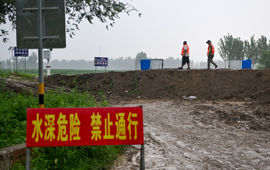 Các tình nguyện viên kiểm tra bờ kè dọc theo một con sông ở Thiên Tân, ngày 1.8.2023. Ảnh: Xinhua