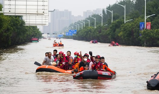 Người dân sơ tán qua nước lũ ở Trác Châu, tỉnh Hà Bắc, Trung Quốc, ngày 2.8.2023. Ảnh: VCG