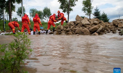Lính cứu hỏa chuyển đá để chặn lũ ở Mẫu Đơn Giang, Hắc Long Giang,  ngày 5.8.2023. Ảnh: Xinhua