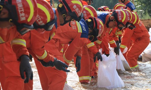 Lính cứu hỏa Trung Quốc chuyển bao cát ở quận Dương Minh, thành phố Mẫu Đơn Giang, tỉnh Hắc Long Giang. Ảnh: Xinhua