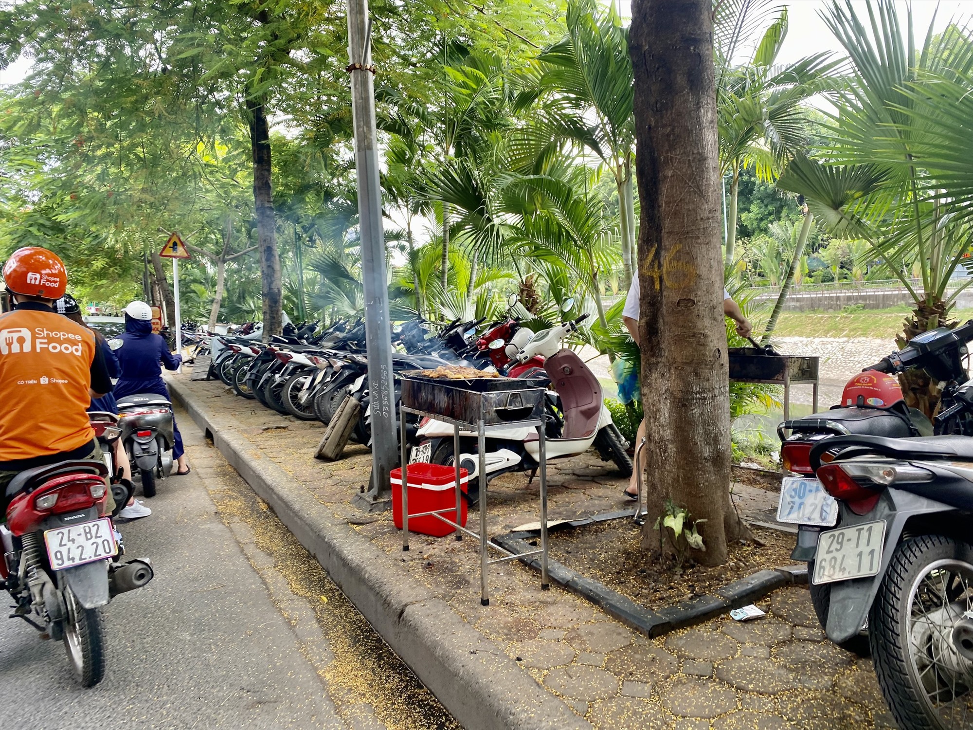 Một quán cơm trên đường Nguyễn Khang ngang nhiên đặt bếp nướng trên vỉa hè. Ảnh: Vĩnh Hoàng