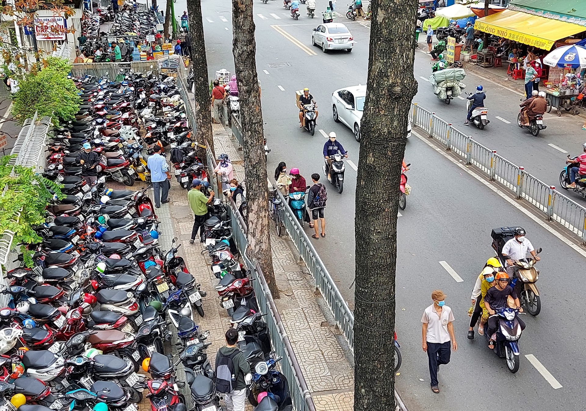 Vỉa hè đường Nguyễn Chí Thanh (Quận 5) bên hông Bệnh viện Chợ Rẫy bị trưng dụng giữ xe máy, đẩy người đi bộ xuống lòng đường. Ảnh: Minh Quân