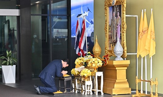 Cựu Thủ tướng Thái Lan Thaksin Shinawatra quỳ lạy trước chân dung Nhà vua Thái Lan tại sân bay Don Mueang ở Bangkok khi trở về ngày 22.8. Ảnh: AFP