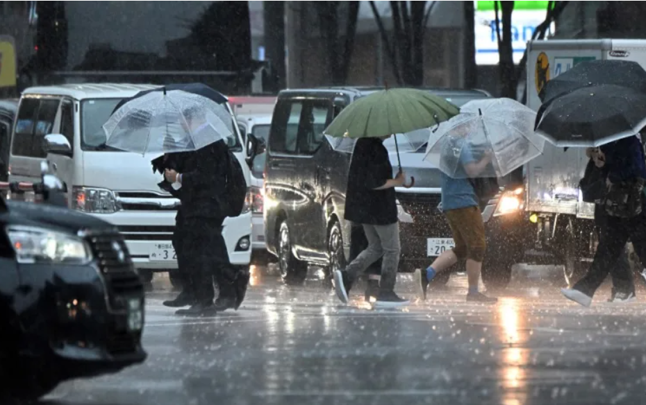 Người dân đi bộ dọc con phố dưới cơn mưa lớn khi bão Haikui đang đến gần ở Tokyo, ngày 8.9.2023. Ảnh: AFP