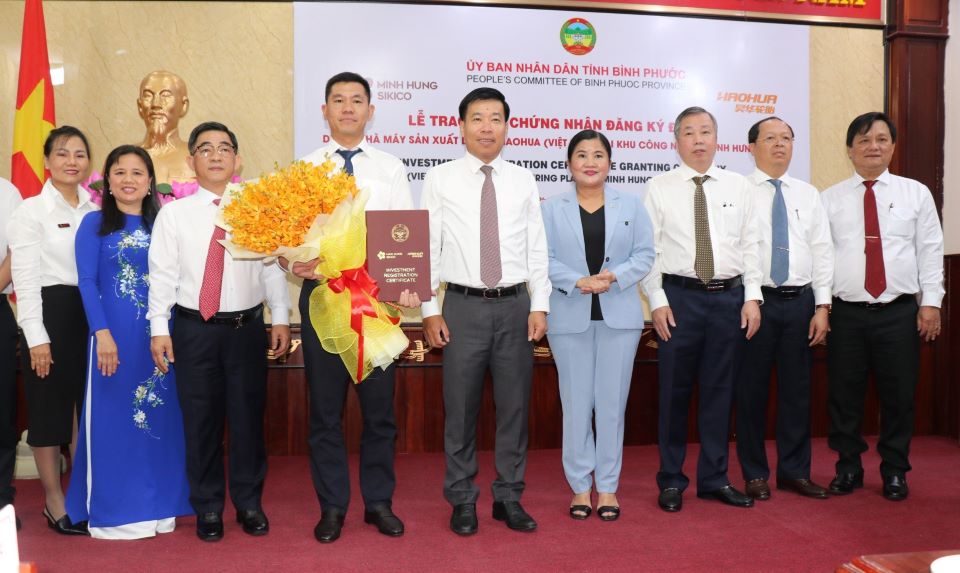 Lãnh đạo tỉnh Bình Phước trao giấy chứng nhận và tặng hoa chúc mừng nhà đầu tư.  Ảnh: Sở TTTT Bình Phước cung cấp