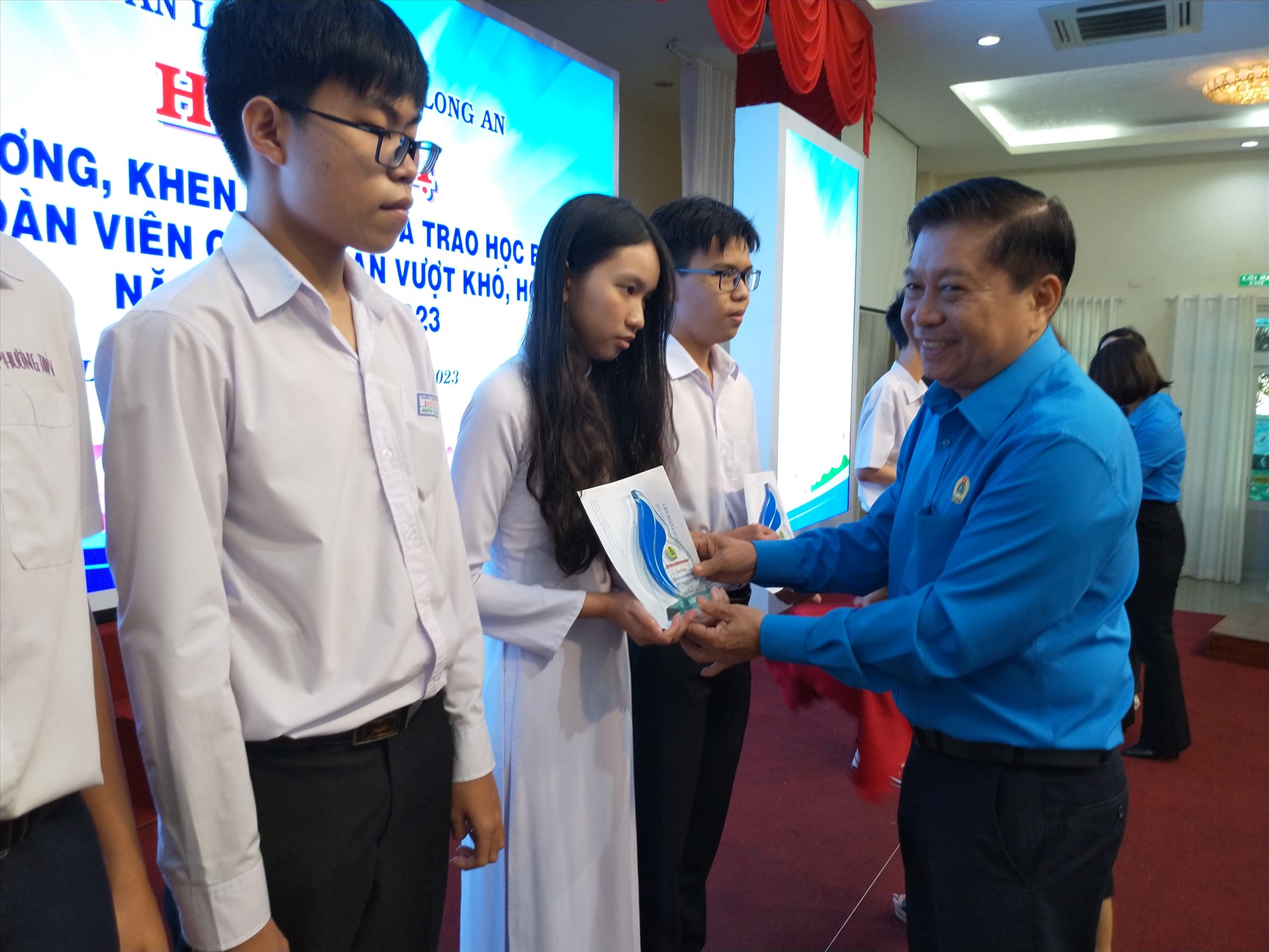 Chủ tịch LĐLĐ tỉnh Long An - ông Nguyễn Văn Quí trao thưởng cho học sinh là con công đoàn viên. Ảnh: K.Q
