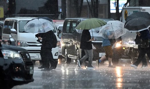Người dân đi bộ dọc con phố dưới cơn mưa lớn khi bão Haikui đang đến gần Tokyo, ngày 8.9.2023. Ảnh: AFP