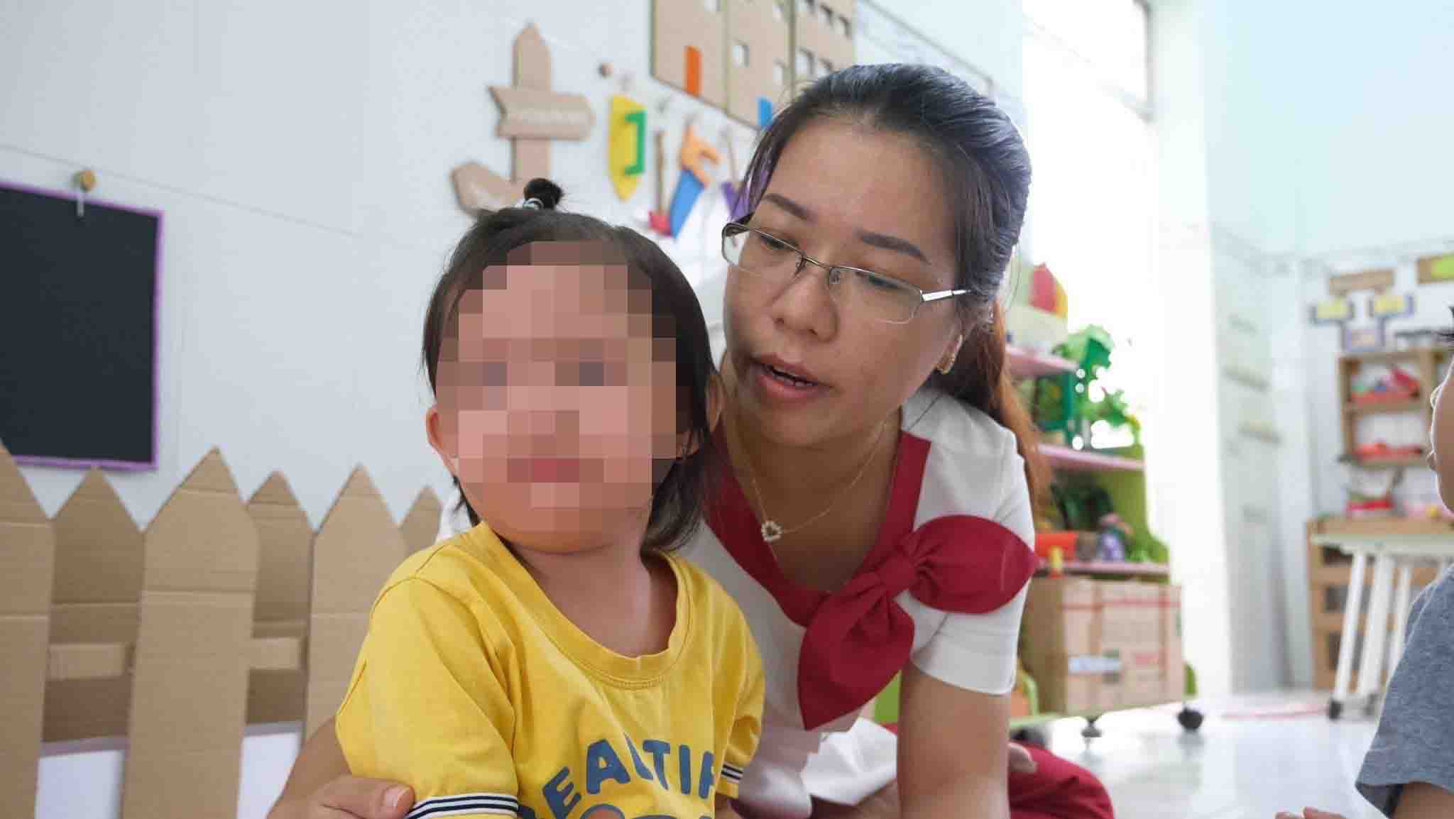 Chị Mỹ Cầm dỗ dành các bé khóc khi xa ba mẹ trong dịp đầu năm học. Ảnh: Phong Linh