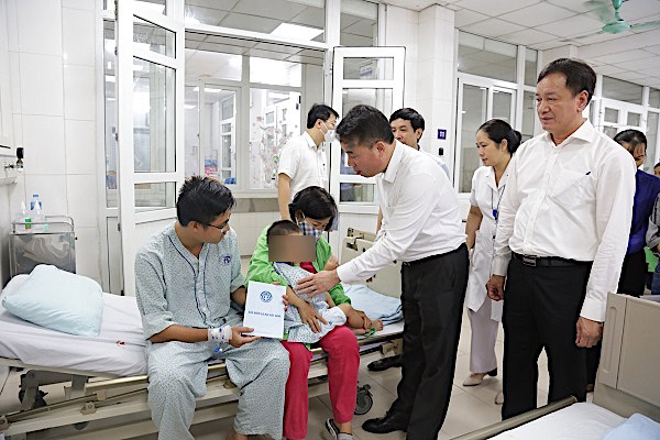 Tổng Giám đốc BHXH Việt Nam Nguyễn Thế Mạnh trao quà cho các nạn nhân vụ cháy chung cư mini ở phố Khương Hạ, ngày 12.9. Ảnh: Hà Anh