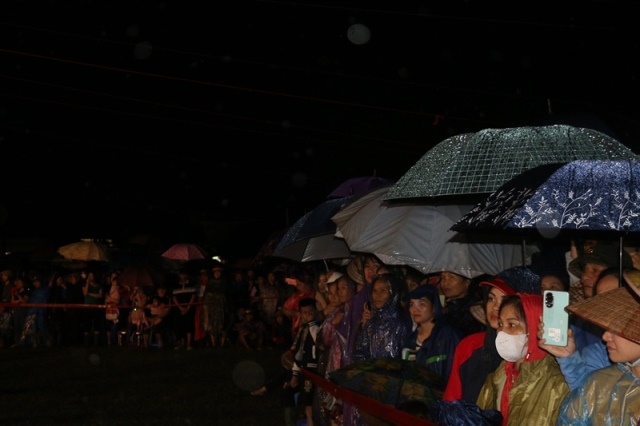 Người dân đội mưa theo dõi chương trình.