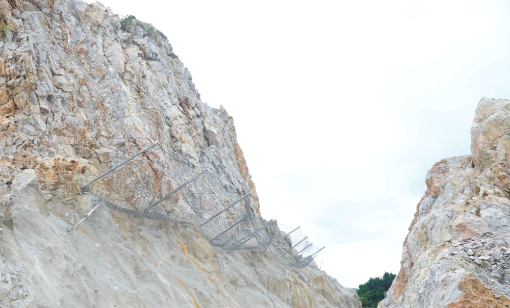 Đơn vị thi công lắp đặt hệ thống lưới sắt ở vách núi, nhằm ngăn ngừa việc đá rơi xuống đường. Ảnh: Minh Hoàng 