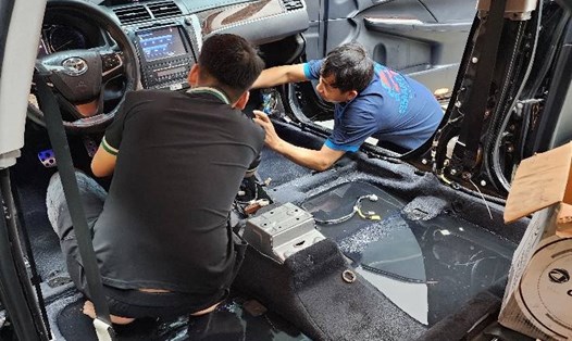Thợ xử lý ôtô bị ngập nước. Ảnh: Quốc Hương 