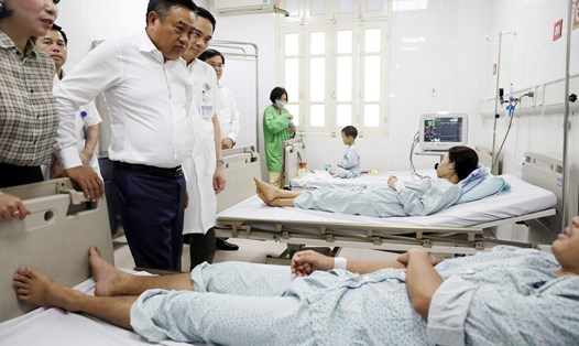 Chủ tịch UBND TP Hà Nội Trần Sỹ Thanh thăm hỏi 3 nạn nhân vụ cháy là người cùng một gia đình đang điều trị tích cực tại Bệnh viện Xanh Pôn. Ảnh: HNP