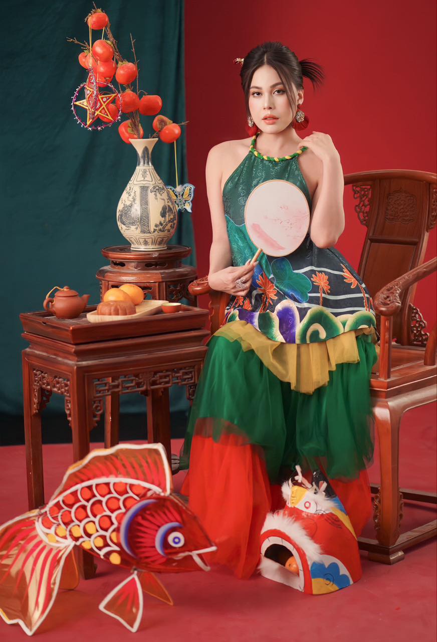 Trong phong cách chụp hình với lồng đèn cá chép và đầu lân, người đẹp diện áo yếm cách tân họa tiết hoa sen làm nổi bật nét đặc trưng của ngày Tết Trung thu trong văn hóa phương Đông.  