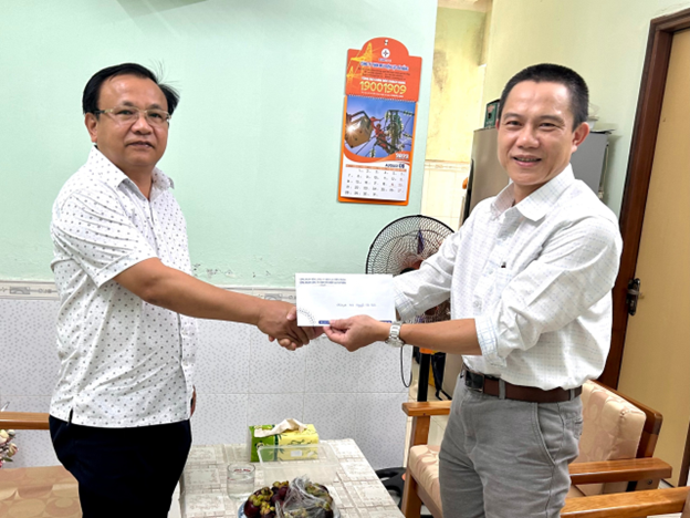 Chủ tịch Công đoàn Công ty Điện lực Đà Nẵng Trần Đình Lành (bên trái) trao hỗ trợ cho đoàn viên. Ảnh: CĐ ĐLVN