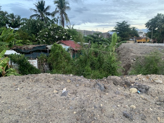 Nhiều ngôi nhà người dân nằm lọt thỏm bởi đất đá thi công dự án khu tái định cư Ngọc Hiệp. Ảnh: Hữu Long