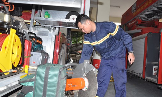 Trung tá Phạm Thanh Tâm – Phó đội trưởng Đội chữa cháy và cứu nạn cứu hộ khu vực số 2 - với các phương tiện bên trong một xe chữa cháy. Ảnh: Quế Chi 
