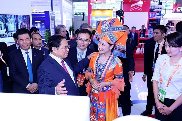 Thủ tướng Phạm Minh Chính tham quan khu gian hàng thương mại của Việt Nam và Trung Quốc. Ảnh: TTXVN