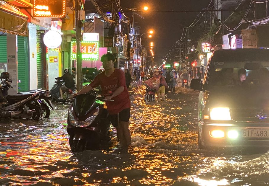 Trên đường Phan Huy Ích(quận Gò Vấp) nước ngập sâu khiến xe cộ qua lại bị chết máy, người dân vất vả sắt xe trên đường. 