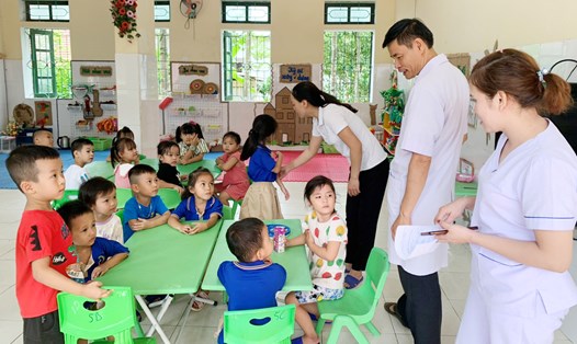 Cán bộ y tế kiểm tra, tuyên truyền phòng tránh, cách điều trị đau mắt đỏ cho học sinh ở huyện Hương Khê. Ảnh: Trần Tuấn.