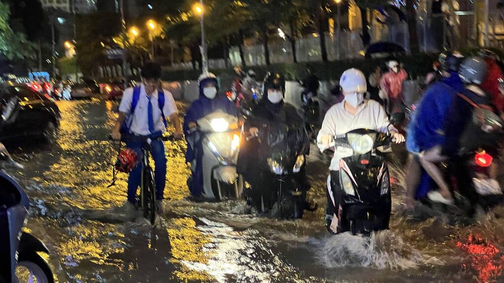 Tối ngày 17.9, hàng loạt tuyến đường ở Quận 7 vẫn bị ngập nặng do cơn mưa từ chiều đến tối cùng ngày, người dân bì bõm trong nước đi lại khó khăn.