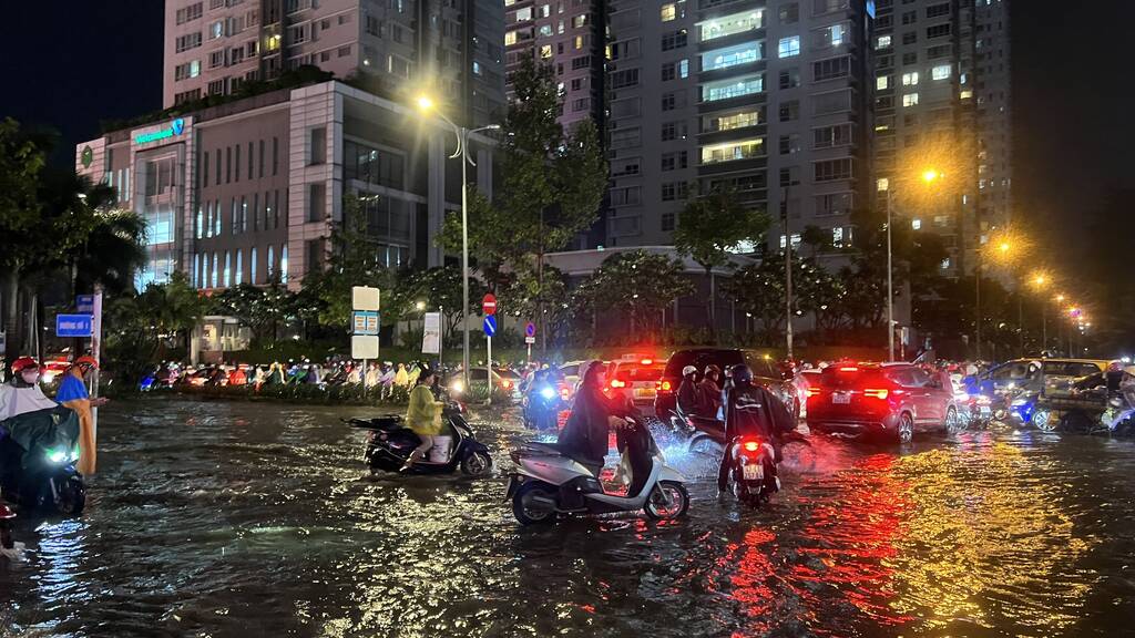 Trên đường Phan Huy Ích (quận Gò Vấp) nước ngập sâu khiến xe cộ qua lại bị chết máy, người dân vất vả dắt xe trên đường.