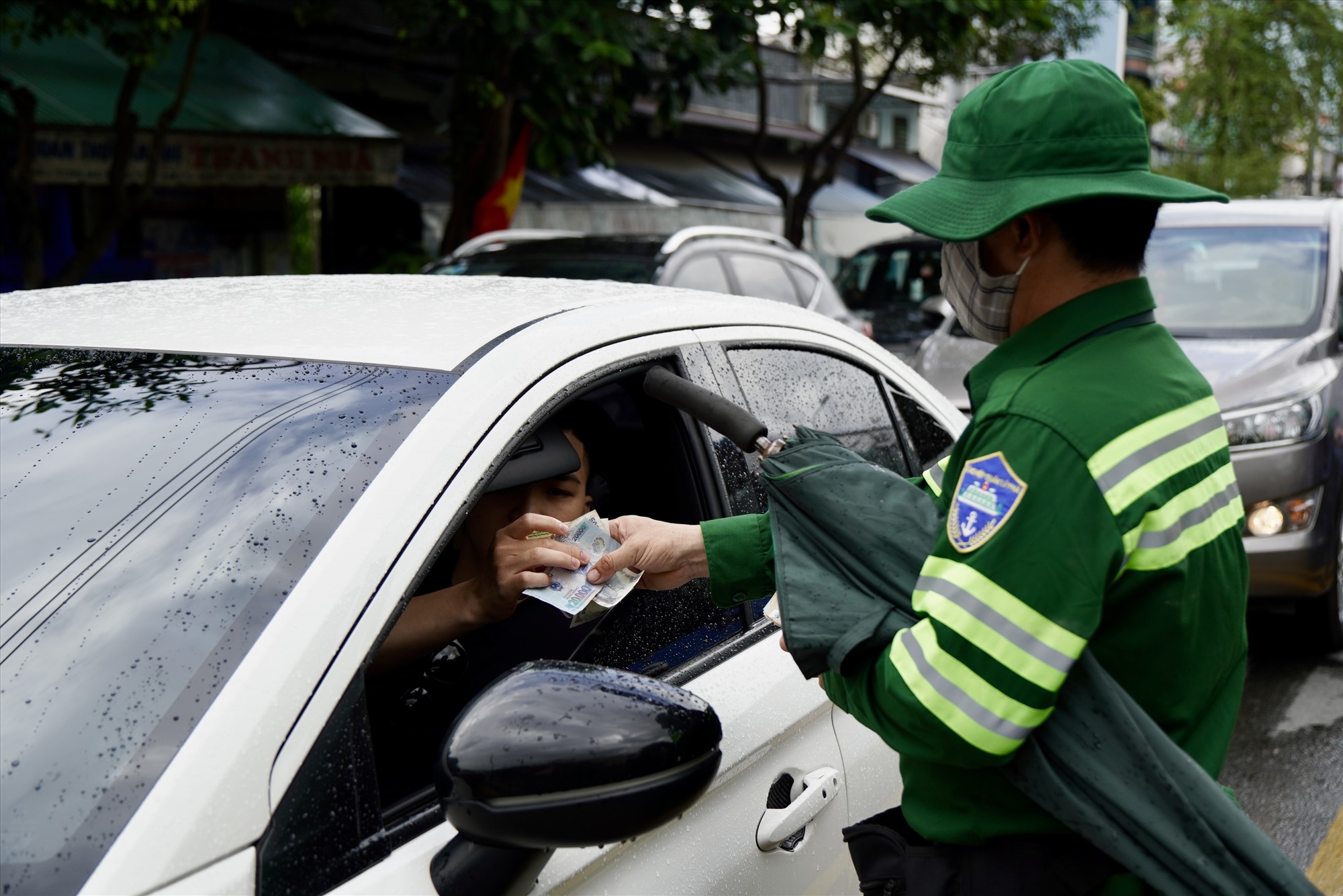 Một số nhân viên bán vé tại phà Bình Khánh phải di chuyển hàng trăm mét để bán vé cho xe ôtô nhằm giảm áp lực ùn ứ.