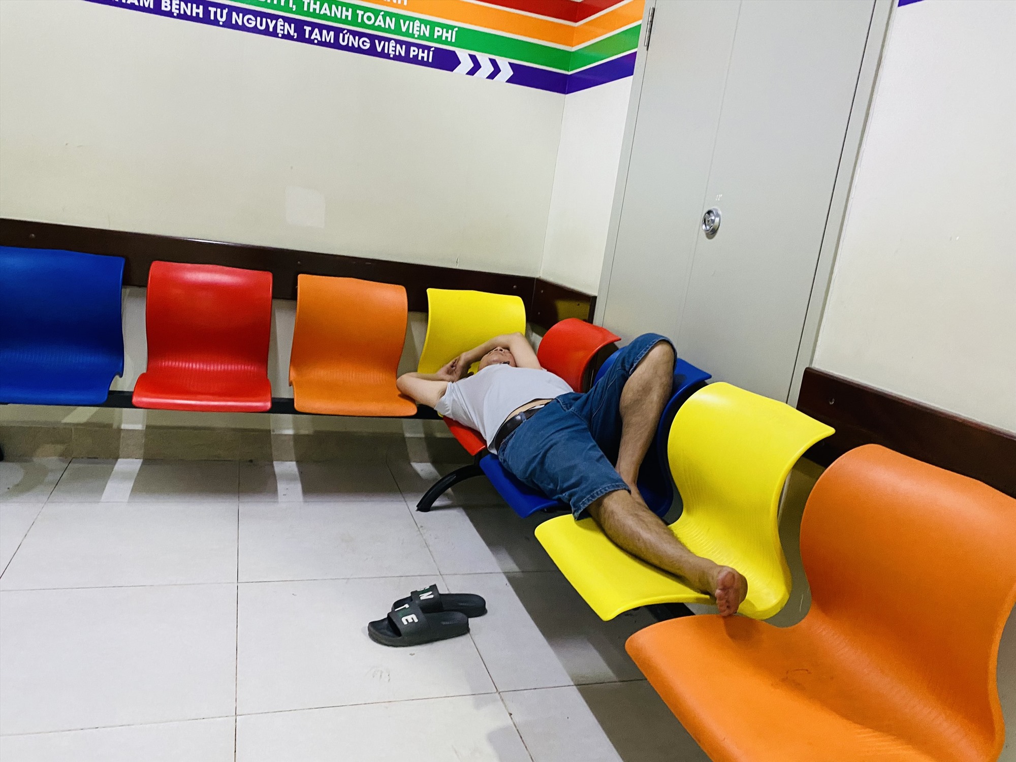 Người nhà bệnh nhân tranh thủ nghỉ ngơi tại hàng ghế ở các hành lang của bệnh viện. 