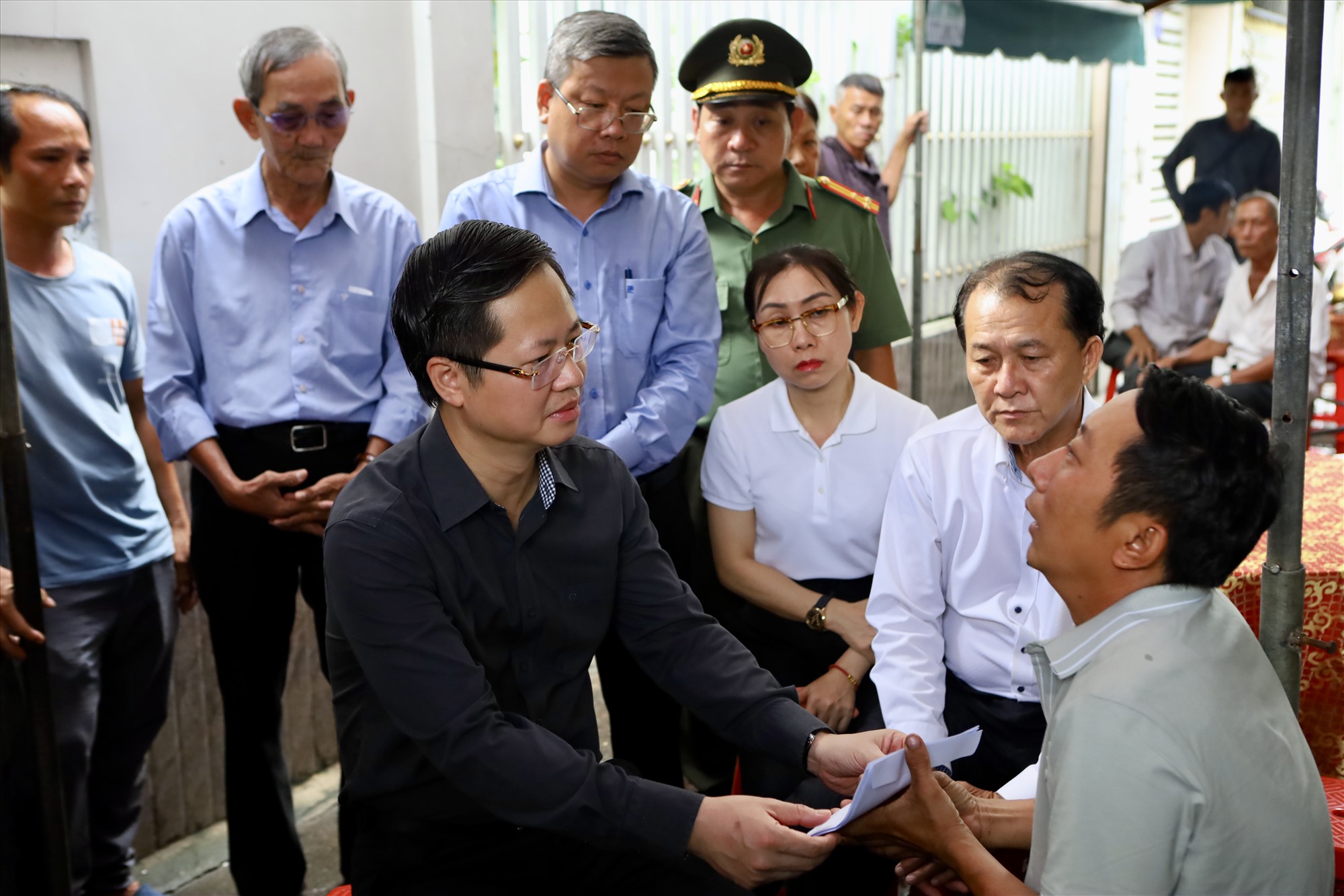 Chủ tịch UBND tỉnh Bình Thuận Đoàn Anh Dũng chia sẻ nỗi đau với người chồng, cha của các nạn nhân. Ảnh: Duy Tuấn