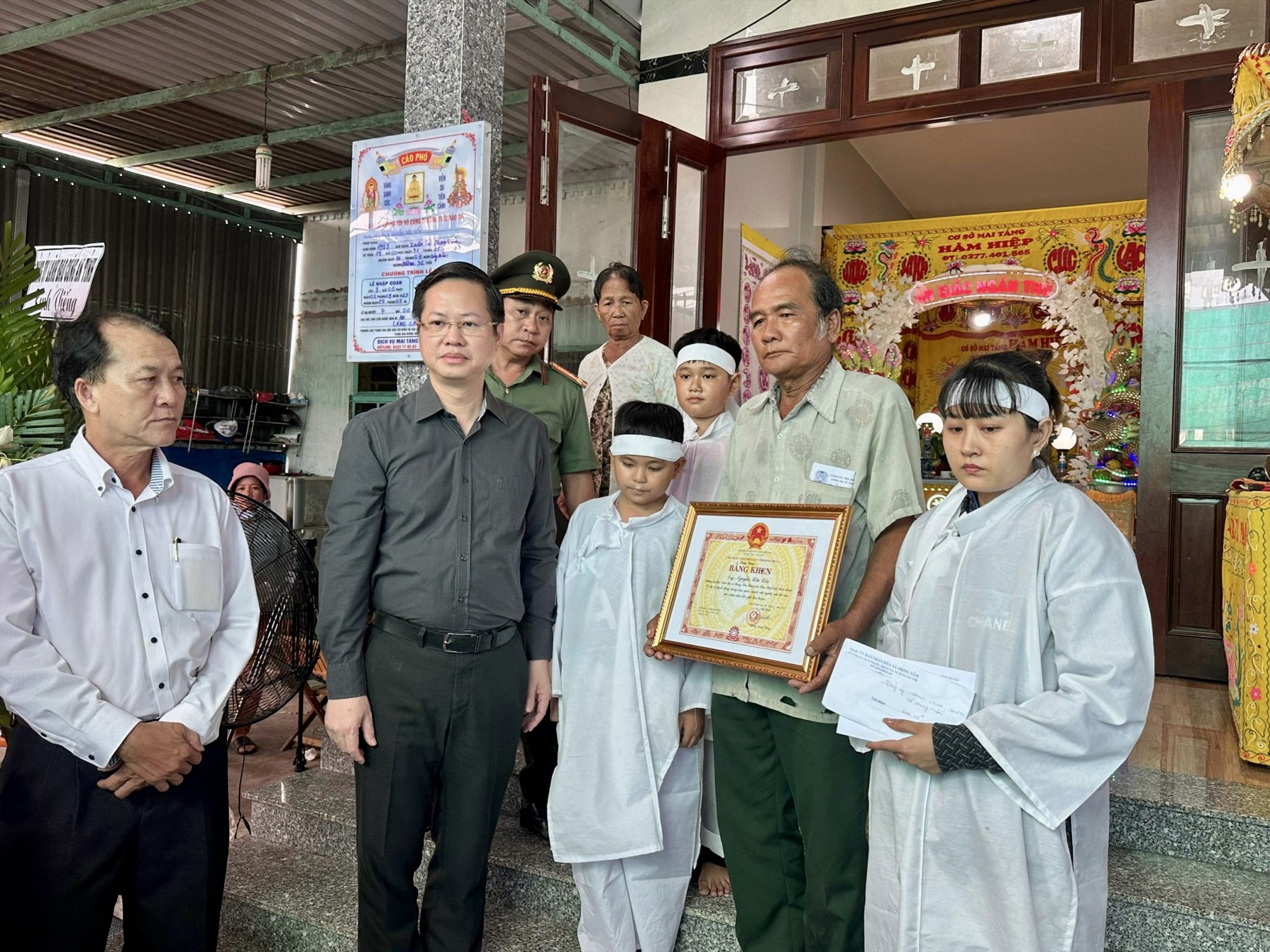 Đại diện gia đình nhận bằng khen chủ tịch UBND tỉnh Bình Thuận truy tặng cho anh Đốn. Ảnh: Duy Tuấn