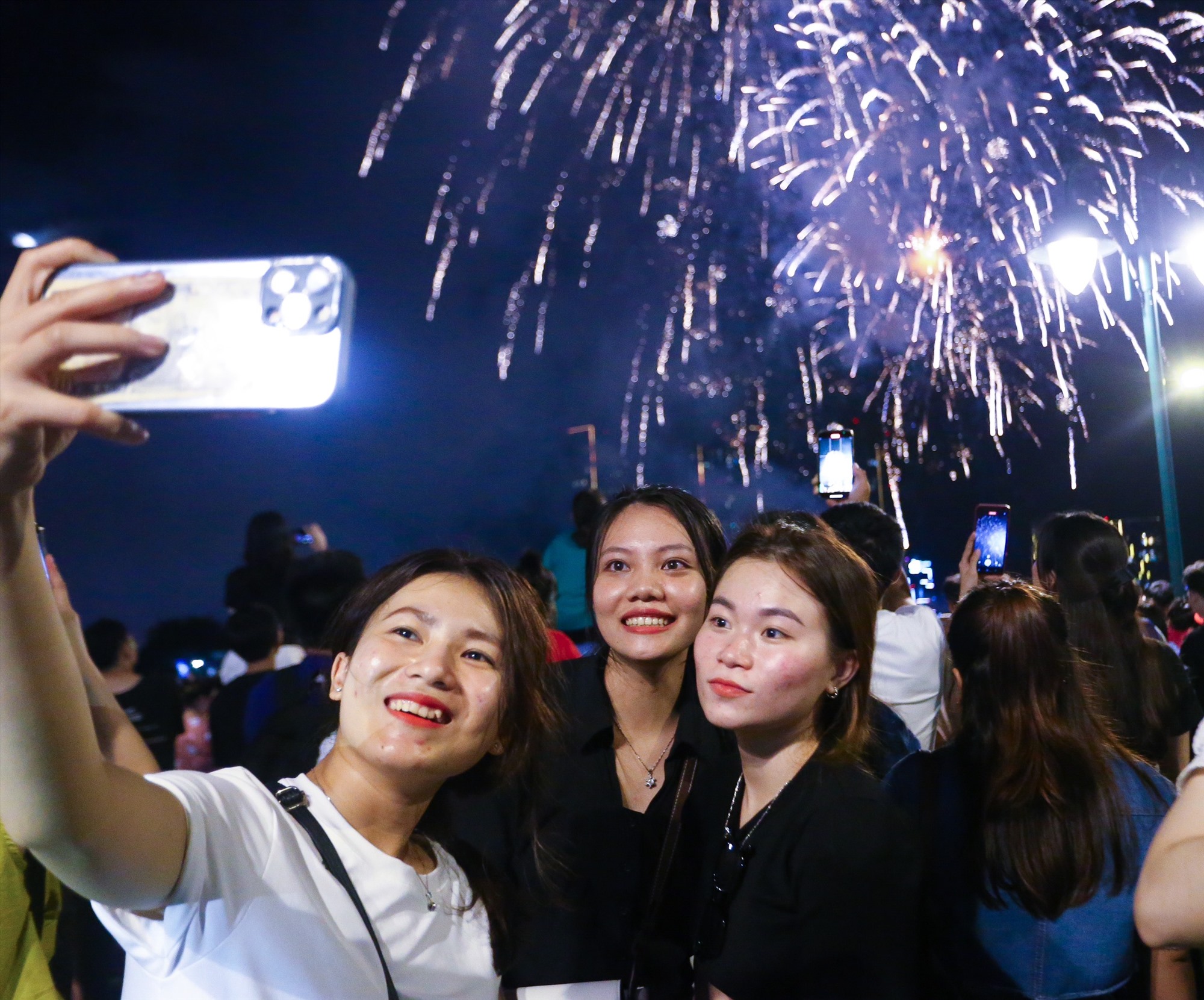    Người dân thể hiện cảm xúc ăn mừng bên những chùm pháo hoa tung ra rực sáng cả góc trời ở bến sông Sài Gòn. 
