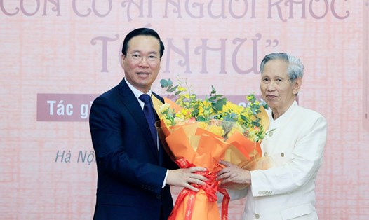 Chủ tịch nước Võ Văn Thưởng tặng hoa chúc mừng nhà văn Võ Bá Cường. Ảnh: TTXVN